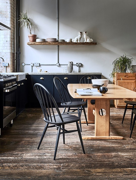 Ercol Windsor Chair and Dining Table In a Modern Dark Navy Kitchen with Rustic Wooden Flooring