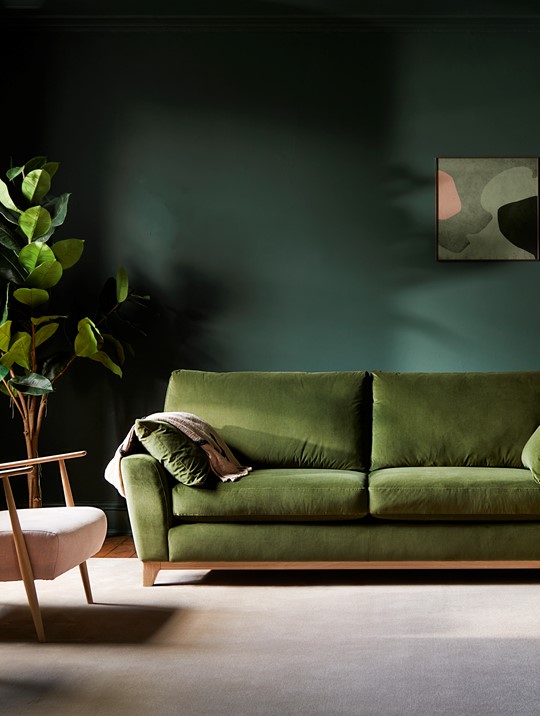 Ercol Novara Velvet Green Sofa And Marlia Dusty Pink Chair in a Green Drenched Room with Monza Tall Sideboard in The Corner