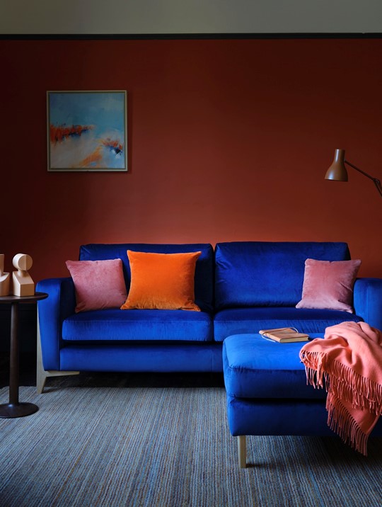 Ercol Marinello Sofa in Blue Velvet with Matching Footstool In A Colourful Living Room