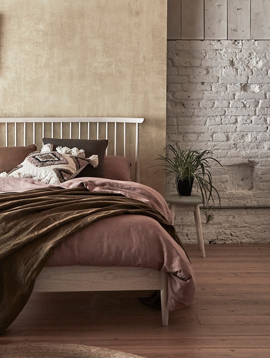 Ercol Bedframe with Dusty Pink Bedding and Olive Green Throw in a Neutral Bedroom