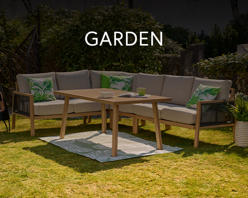 Outdoor garden furniture set with cushioned corner sofa and wooden table on a green lawn with patterned cushions.