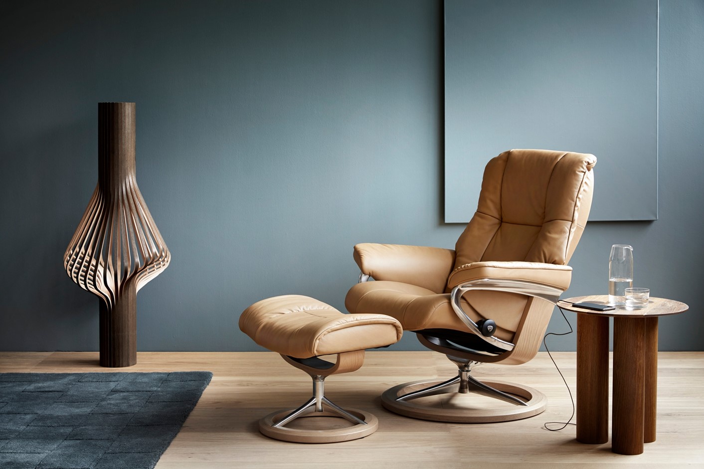stressless consul signature recliner chair in tan leather, in a blue room